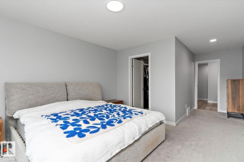 Recessed ceiling lighting, light gray wall paint, light gray carpeting, white trim, and a built-in closet with a white door - 3241 Kulay Way Sw, Edmonton, AB - Indoor Photo Showing Bedroom