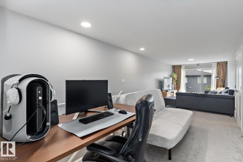 Recessed lighting illuminating the open-concept space with light-toned walls and carpeting - 3241 Kulay Way Sw, Edmonton, AB - Indoor Photo Showing Office