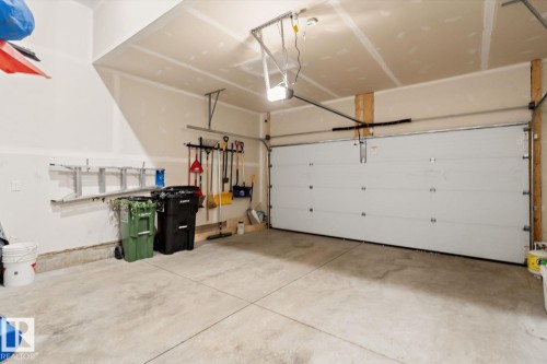 Spacious garage with an automatic overhead door, concrete flooring, and unfinished walls - 3241 Kulay Way Sw, Edmonton, AB - Indoor Photo Showing Garage