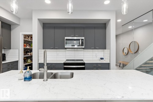 Kitchen island with a double basin stainless steel sink and gooseneck faucet - 3241 Kulay Way Sw, Edmonton, AB - Indoor Photo Showing Kitchen With Stainless Steel Kitchen With Double Sink With Upgraded Kitchen