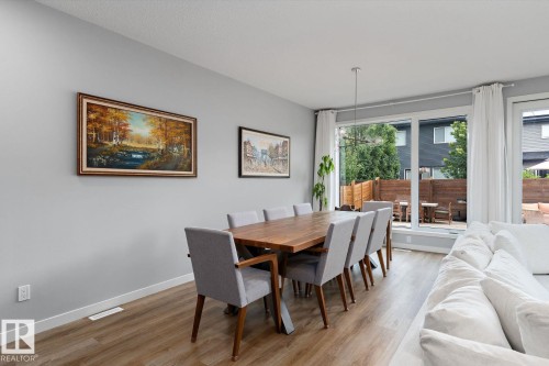 Wood-finish flooring throughout, with a contemporary pendant light fixture - 3241 Kulay Way Sw, Edmonton, AB - Indoor