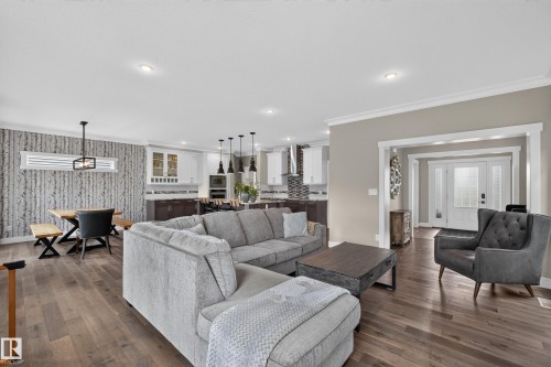 Open-concept living area featuring wood-finish flooring, recessed lighting, and a prominent front entry with sidelights - 1399 Graydon Hill Way Sw, Edmonton, AB - Indoor Photo Showing Living Room
