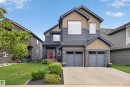 Multi-level exterior with mixed siding, stone accents, and a red entry door - 1399 Graydon Hill Way Sw, Edmonton, AB 