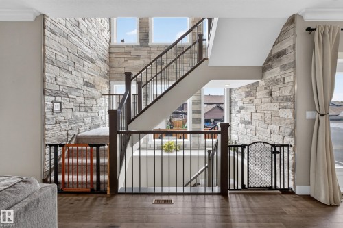 Two-story stone accent wall with multiple windows - 1399 Graydon Hill Way Sw, Edmonton, AB - Indoor Photo Showing Other Room