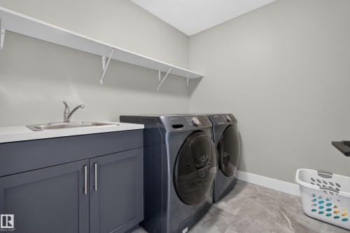 Laundry area with white countertops, undermount sink, and dark gray cabinetry - 1399 Graydon Hill Way Sw, Edmonton, AB - Indoor Photo Showing Laundry Room