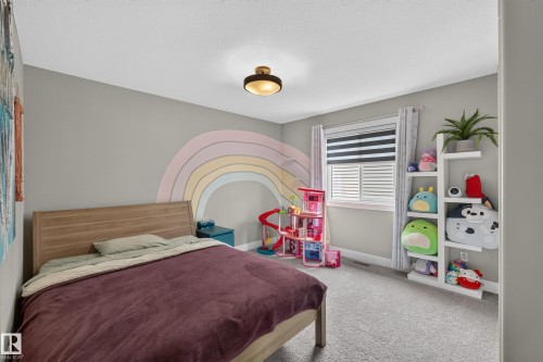 Neutral wall color, window with horizontal blinds, built-in shelving, carpeted flooring, and a ceiling-mounted light fixture - 1399 Graydon Hill Way Sw, Edmonton, AB - Indoor Photo Showing Bedroom