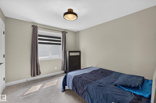Neutral-toned walls complement the textured carpet flooring - 1399 Graydon Hill Way Sw, Edmonton, AB - Indoor Photo Showing Bedroom