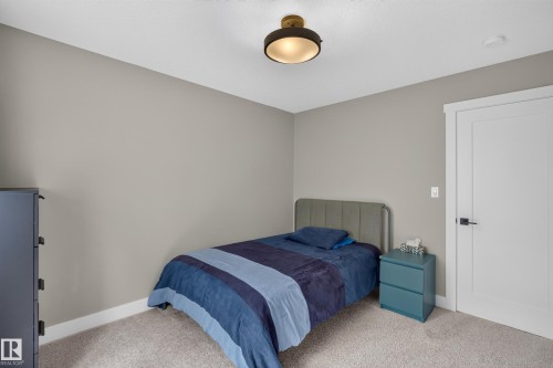 Neutral wall paint, ceiling-mounted light fixture, white interior door, and light-toned carpet flooring - 1399 Graydon Hill Way Sw, Edmonton, AB - Indoor Photo Showing Bedroom