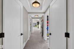 Recessed ceiling with integrated lighting, neutral wall paint, white trim, and light-colored carpeting - 