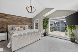 Vaulted ceiling with an orb chandelier, wood-paneled accent wall, and large picture window - 