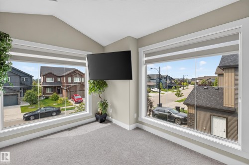 Expansive windows providing abundant natural light, neutral wall tones, and plush carpeting throughout - 1399 Graydon Hill Way Sw, Edmonton, AB -  Photo Showing Other Room