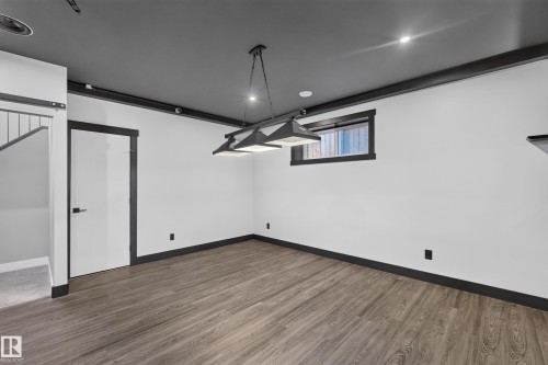 Wood-finish flooring, recessed lighting, and a modern chandelier - 1399 Graydon Hill Way Sw, Edmonton, AB 