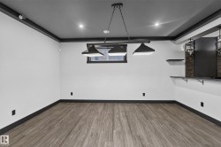Wood-finish flooring, recessed lighting, industrial-style pendant lighting, built-in shelf, and a built-in counter - 