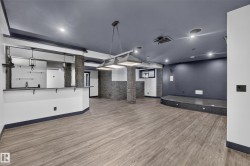 Wood-finish flooring, recessed lighting, and a built-in bar area with pendant lighting - 