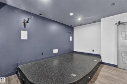 Built-in raised platform with integrated lighting, wood-finish flooring, and a sliding barn door - 