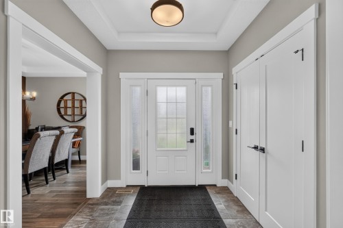 Entryway featuring a white paneled door with sidelights, tray ceiling, and tile flooring - 1399 Graydon Hill Way Sw, Edmonton, AB - Indoor Photo Showing Other Room