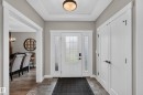 Entryway featuring a white paneled door with sidelights, tray ceiling, and tile flooring - 1399 Graydon Hill Way Sw, Edmonton, AB 