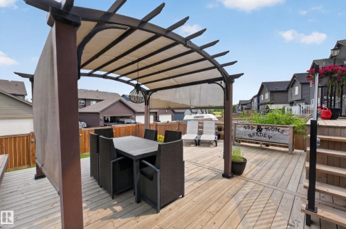 Expansive wood-finish deck featuring a pergola with a retractable fabric canopy and a contemporary chandelier - 1399 Graydon Hill Way Sw, Edmonton, AB - Outdoor With Deck Patio Veranda With Exterior
