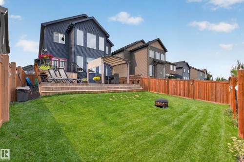 Expansive green lawn with a wooden privacy fence, multi-level wooden deck, and an attached pergola - 1399 Graydon Hill Way Sw, Edmonton, AB - Outdoor With Deck Patio Veranda