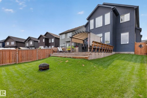 Expansive backyard featuring a tiered wood deck with pergola, wood fence, and a generous lawn - 1399 Graydon Hill Way Sw, Edmonton, AB - Outdoor With Deck Patio Veranda