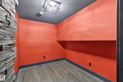 Wood-finish flooring, accent wall with stacked stone, built-in shelving, flush-mount ceiling light - 