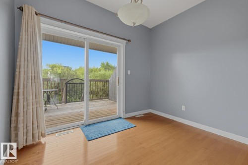 Wood-finish flooring with white trim and light blue walls - #9 13215 153 Av Nw, Edmonton, AB - Indoor Photo Showing Other Room