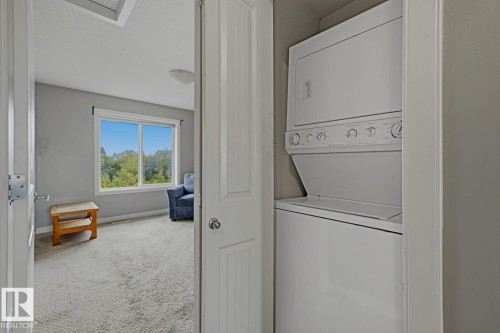 Integrated white stackable laundry appliances - #9 13215 153 Av Nw, Edmonton, AB - Indoor Photo Showing Laundry Room