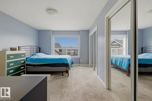 Light-toned carpeting, white trim, and a window providing natural illumination - #9 13215 153 Av Nw, Edmonton, AB - Indoor Photo Showing Bedroom