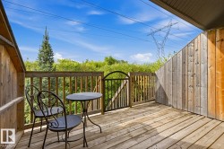 Wood-plank outdoor deck with wood railing and black metal gate - 