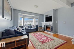 Hardwood-finish flooring, built-in fireplace with tile surround, bay window, and recessed media niche - 