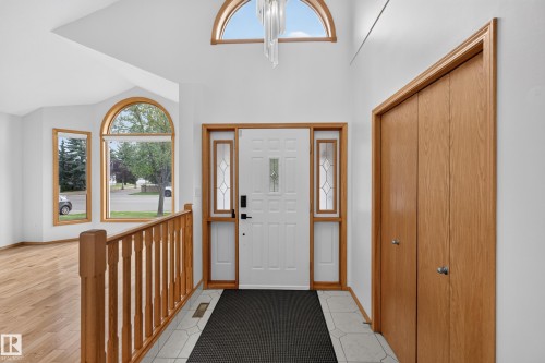 Vaulted ceiling with an arched transom window, wood-finish flooring, and white interior doors - 306 Twin Brooks Drive Nw, Edmonton, AB 