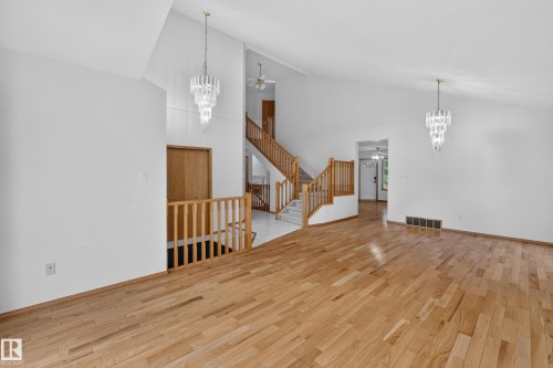 Wood-finish flooring with vaulted ceilings, a prominent wooden staircase, and decorative pendant light fixtures - 306 Twin Brooks Drive Nw, Edmonton, AB 