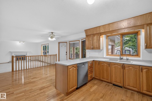 Hardwood flooring, wood cabinetry, white countertops, built-in dishwasher, and a fireplace - 306 Twin Brooks Drive Nw, Edmonton, AB 