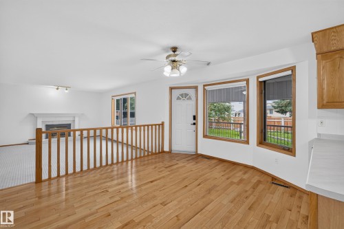 Hardwood flooring, bay windows, ceiling fan, white entry door with decorative glass, and a white fireplace - 306 Twin Brooks Drive Nw, Edmonton, AB 