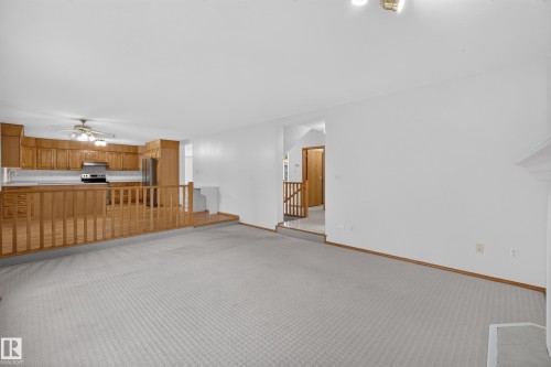Open concept living space with light-colored carpeting, white walls, and wood trim - 306 Twin Brooks Drive Nw, Edmonton, AB 