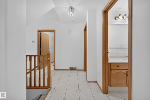 Tiled flooring, wood-finish trim and doors, wood-finish stair railing, recessed ceiling light fixture, and vanity with integrated sink - 306 Twin Brooks Drive Nw, Edmonton, AB 