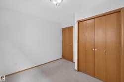 Light-colored wall-to-wall carpeting, wood-finish interior doors, and a ceiling-mounted light fixture - 