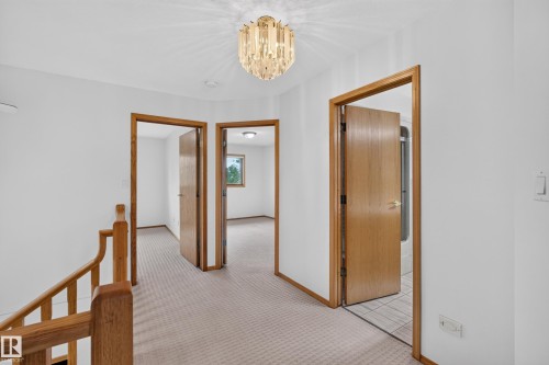 Carpeted hallway with wood trim and doors - 306 Twin Brooks Drive Nw, Edmonton, AB 