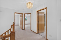 Carpeted hallway with wood trim and doors - 