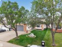 Attached garage with a panel door, brick facade accents, and a bay window - 306 Twin Brooks Drive Nw, Edmonton, AB 