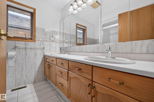 Dual vanity with light wood-finish cabinetry, integrated sinks, and chrome faucets - 306 Twin Brooks Drive Nw, Edmonton, AB 