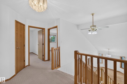 Carpeted hallway with wood doors and trim - 306 Twin Brooks Drive Nw, Edmonton, AB 