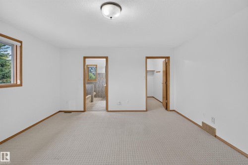 Carpeted flooring, white wall finishes, wood-trim windows, and an overhead flush-mount light fixture - 306 Twin Brooks Drive Nw, Edmonton, AB 