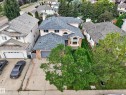 Pitched shingle roof, two-car garage, arched entry window, brick facade accents, mature trees - 306 Twin Brooks Drive Nw, Edmonton, AB 