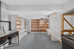 Built-in shelving, utility sink, long workspace, and exposed ceiling beams - 