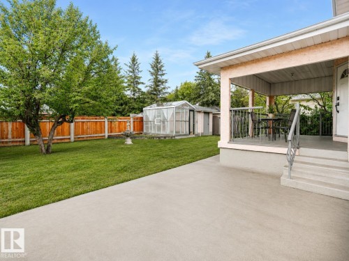 Expansive concrete patio with covered porch, concrete steps, and metal railings - 306 Twin Brooks Drive Nw, Edmonton, AB 