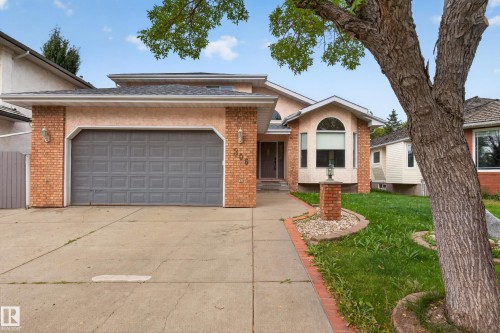 Stucco and brick exterior with a gray garage door - 306 Twin Brooks Drive Nw, Edmonton, AB 