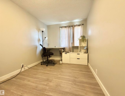 Wood-finish flooring, neutral wall paint, and window with natural light - #13 18010 98 Av Nw Nw, Edmonton, AB - Indoor