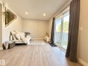Wood-finish flooring throughout, recessed ceiling lighting, and a sliding glass door leading to the exterior - #13 18010 98 Av Nw Nw, Edmonton, AB  - Indoor Photo Showing Other Room 