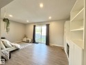 Recessed ceiling lighting, wood-finish flooring, sliding glass door, built-in shelving, and an integrated electric fireplace - #13 18010 98 Av Nw Nw, Edmonton, AB  - Indoor 